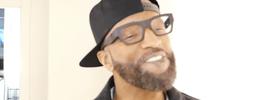 Man wearing glasses and a black cap.